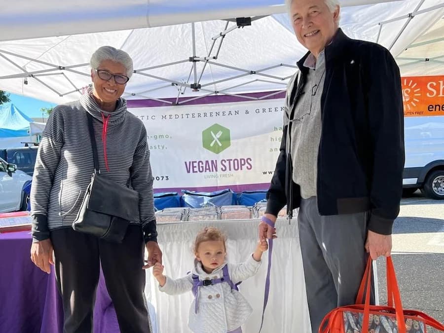 Customers visiting the Vegan Stops farmers market stand